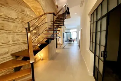 a winding staircase in a building with a stone wall at Preciosa Casa Centro Histórico Jerez, Parking privado+ WI-FI in Jerez de la Frontera