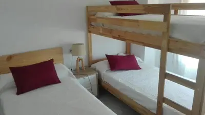 a bedroom with two bunk beds with red pillows at Jardines de Vistahermosa in El Puerto de Santa María
