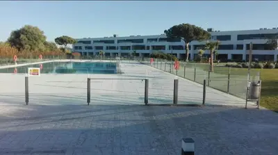 a basketball court with a volley ball net in front of a building at Jardines de Vistahermosa in El Puerto de Santa María
