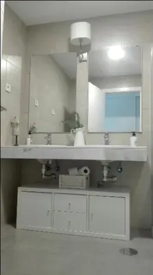 a bathroom with two sinks and a large mirror at Jardines de Vistahermosa in El Puerto de Santa María