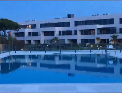 a large building with a swimming pool in front of a building at Jardines de Vistahermosa in El Puerto de Santa María