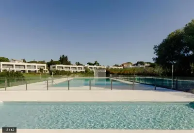 a swimming pool with a fence around it at Jardines de Vistahermosa in El Puerto de Santa María