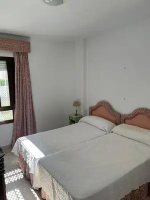 a bedroom with two beds and a window at Apartamento Playa El Manantial in El Puerto de Santa María