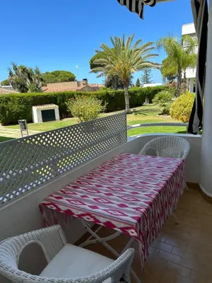 a table and chairs on a balcony with palm trees at Apartamento Playa El Manantial in El Puerto de Santa María