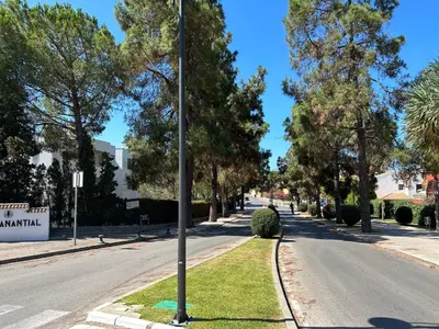 a pole on the side of a street with trees at Apartamento Playa El Manantial in El Puerto de Santa María