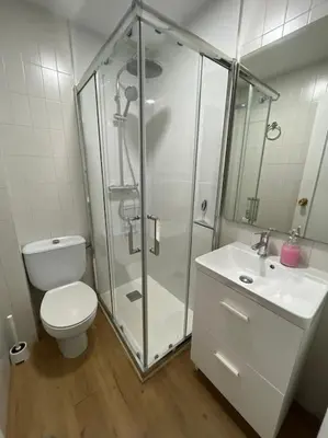 a bathroom with a shower and a toilet and a sink at Apartamento Playa El Manantial in El Puerto de Santa María
