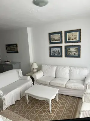 a living room with two white couches and a table at Apartamento Playa El Manantial in El Puerto de Santa María