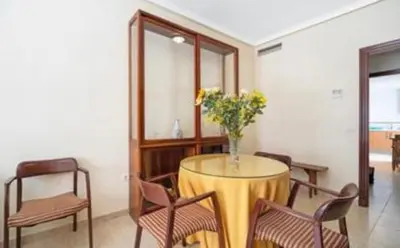 a table with chairs and a vase of flowers on it at Colibri in Puerto Real
