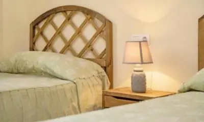 a bedroom with two beds and a lamp on a night stand at Colibri in Puerto Real