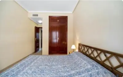 a bedroom with a large bed with a wooden head board at Colibri in Puerto Real