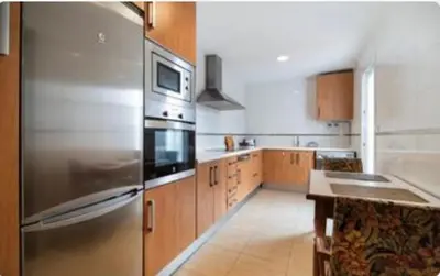a kitchen with a stainless steel refrigerator and wooden cabinets at Colibri in Puerto Real