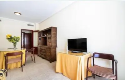 a living room with a television and a table and chairs at Colibri in Puerto Real