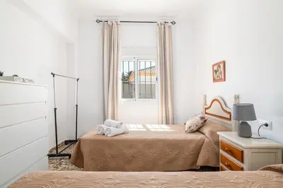a bedroom with two beds and a window at Tramontana in Conil de la Frontera