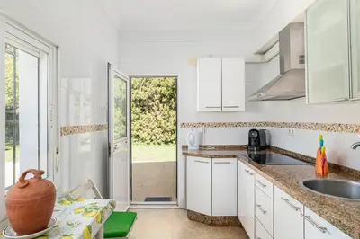 a kitchen with white cabinets and a table with a vase at Tramontana in Conil de la Frontera