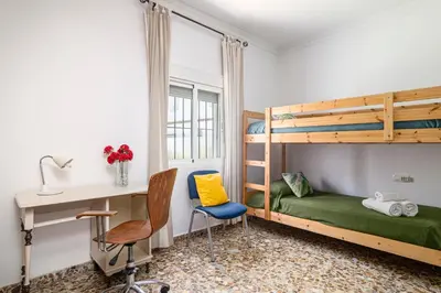 a bedroom with a bunk bed and a desk at Tramontana in Conil de la Frontera