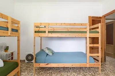 a bedroom with two bunk beds with a blue bed at Tramontana in Conil de la Frontera