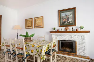 a dining room with a table and a fireplace at Tramontana in Conil de la Frontera