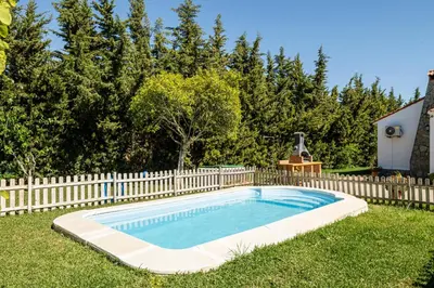 a swimming pool in a yard next to a fence at Tramontana in Conil de la Frontera