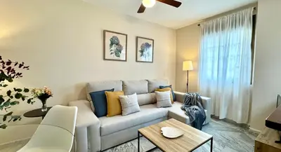 a living room with a couch and a table at Sibs Sanlucar Alcazar - Duplex Recién Reformado in Sanlúcar de Barrameda