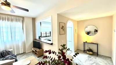 a living room with a ceiling fan and a window at Sibs Sanlucar Alcazar - Duplex Recién Reformado in Sanlúcar de Barrameda