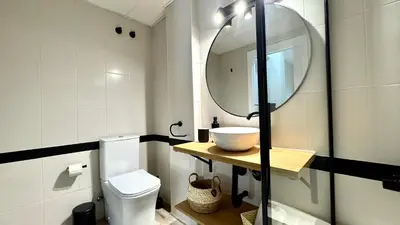 a bathroom with a sink and a toilet and a mirror at Sibs Sanlucar Alcazar - Duplex Recién Reformado in Sanlúcar de Barrameda