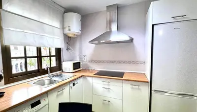 a white kitchen with a sink and a refrigerator at Sibs Sanlucar Alcazar - Duplex Recién Reformado in Sanlúcar de Barrameda