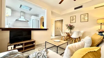 a living room with a couch and a tv and a table at Sibs Sanlucar Alcazar - Duplex Recién Reformado in Sanlúcar de Barrameda
