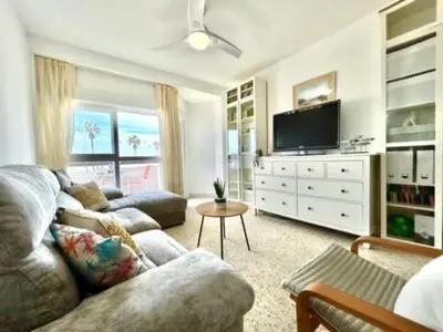 a living room with a couch and a flat screen tv at GATU VALDEPLAYA 1ª linea playa piscina parking 3 dormit 2 baños, 
