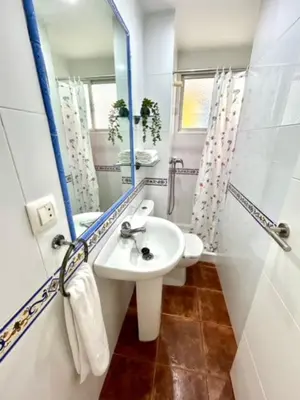 a white bathroom with a sink and a mirror at GATU VALDEPLAYA 1ª linea playa piscina parking 3 dormit 2 baños, 