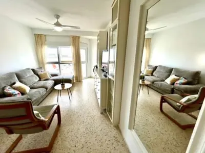 a living room with a couch and a living room with at GATU VALDEPLAYA 1ª linea playa piscina parking 3 dormit 2 baños, 