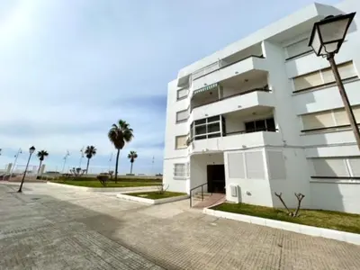 a white building with palm trees in front of it at GATU VALDEPLAYA 1ª linea playa piscina parking 3 dormit 2 baños, 