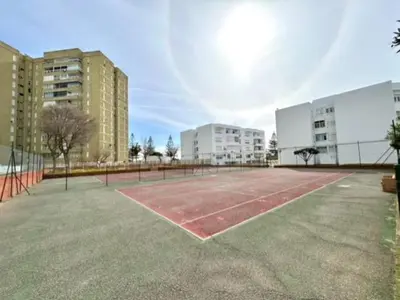 an empty tennis court in the middle of a city at GATU VALDEPLAYA 1ª linea playa piscina parking 3 dormit 2 baños, 