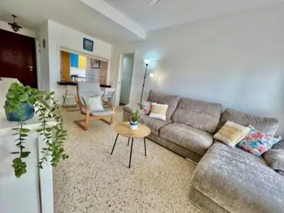 a living room with a couch and a table at GATU VALDEPLAYA 1ª linea playa piscina parking 3 dormit 2 baños, 