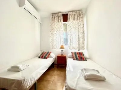 two beds in a room with a window at GATU DULCE junto playa, terraza, aire acc, parking, piscina , 