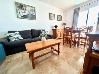 a living room with a couch and a table at GATU DULCE junto playa, terraza, aire acc, parking, piscina , 