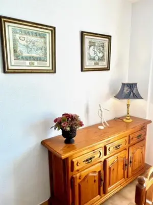 a wooden cabinet with a vase of flowers on top of it at GATU DULCE junto playa, terraza, aire acc, parking, piscina , 