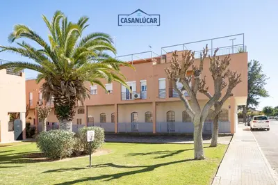 a building with palm trees in front of it at Apartamento mi Gitana in La Jara