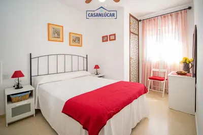 a bedroom with a large bed with a red blanket at Apartamento mi Gitana in La Jara