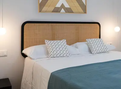 a bedroom with a large bed with white sheets and pillows at Estudio Palacios Sur in El Puerto de Santa María