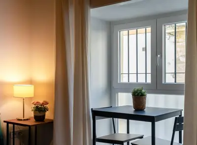 a table and chairs in a room with a window at Estudio Palacios Sur in El Puerto de Santa María