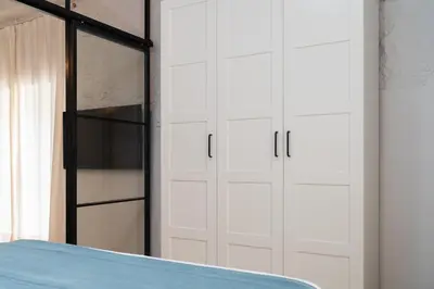 a bedroom with white cabinets and a bed at Estudio Palacios Norte in El Puerto de Santa María