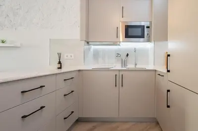 a kitchen with white cabinets and a microwave at Estudio Palacios Norte in El Puerto de Santa María