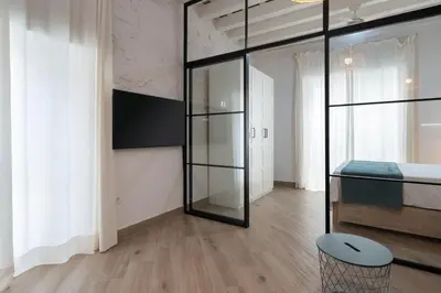 a room with glass walls and a table and a stool at Estudio Palacios Norte in El Puerto de Santa María