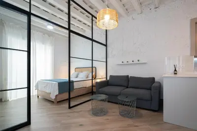 a living room with a couch and a bed at Estudio Palacios Norte in El Puerto de Santa María