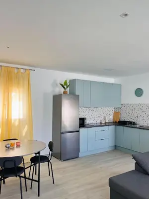 a kitchen with a table and a refrigerator at Casa Robin in Conil de la Frontera