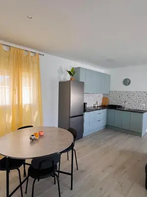 a kitchen with a table and chairs and a refrigerator at Casa Robin in Conil de la Frontera