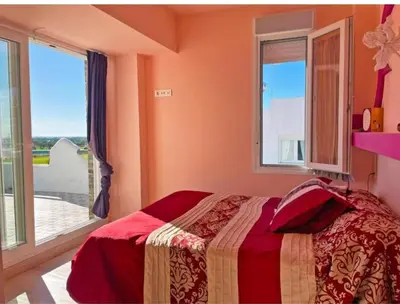 a bedroom with a bed and a large window at Villa Nostra in Puerto Real