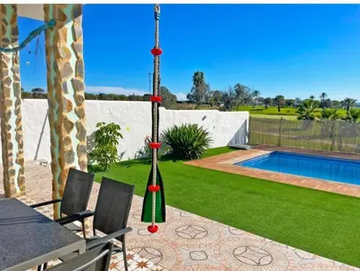 a backyard with a pool and a table and chairs at Villa Nostra in Puerto Real
