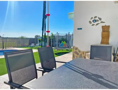 a table and chairs with a playground in the background at Villa Nostra in Puerto Real
