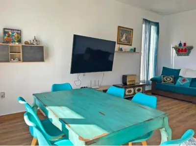 a living room with a green table and blue chairs at Villa Nostra in Puerto Real